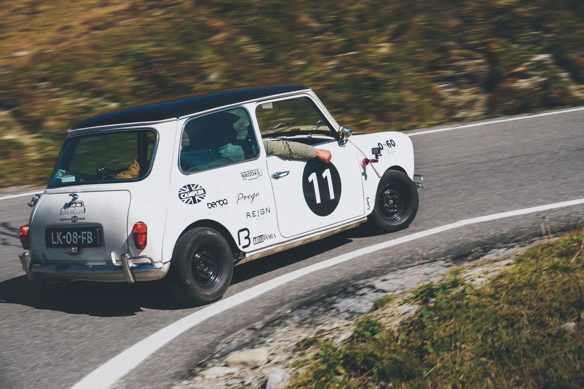 Een witte Mini Cooper 998 Rally crossend door de bocht in een bergachtig landschap