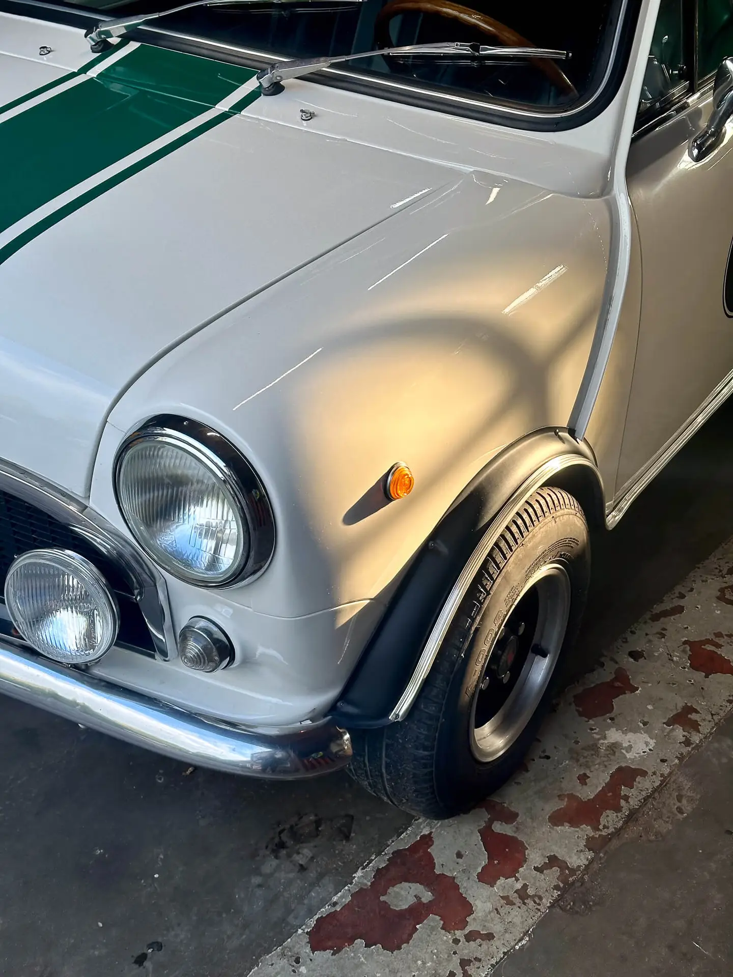 innocenti mini 1001 with green striping over the car and sunrays on the white paint