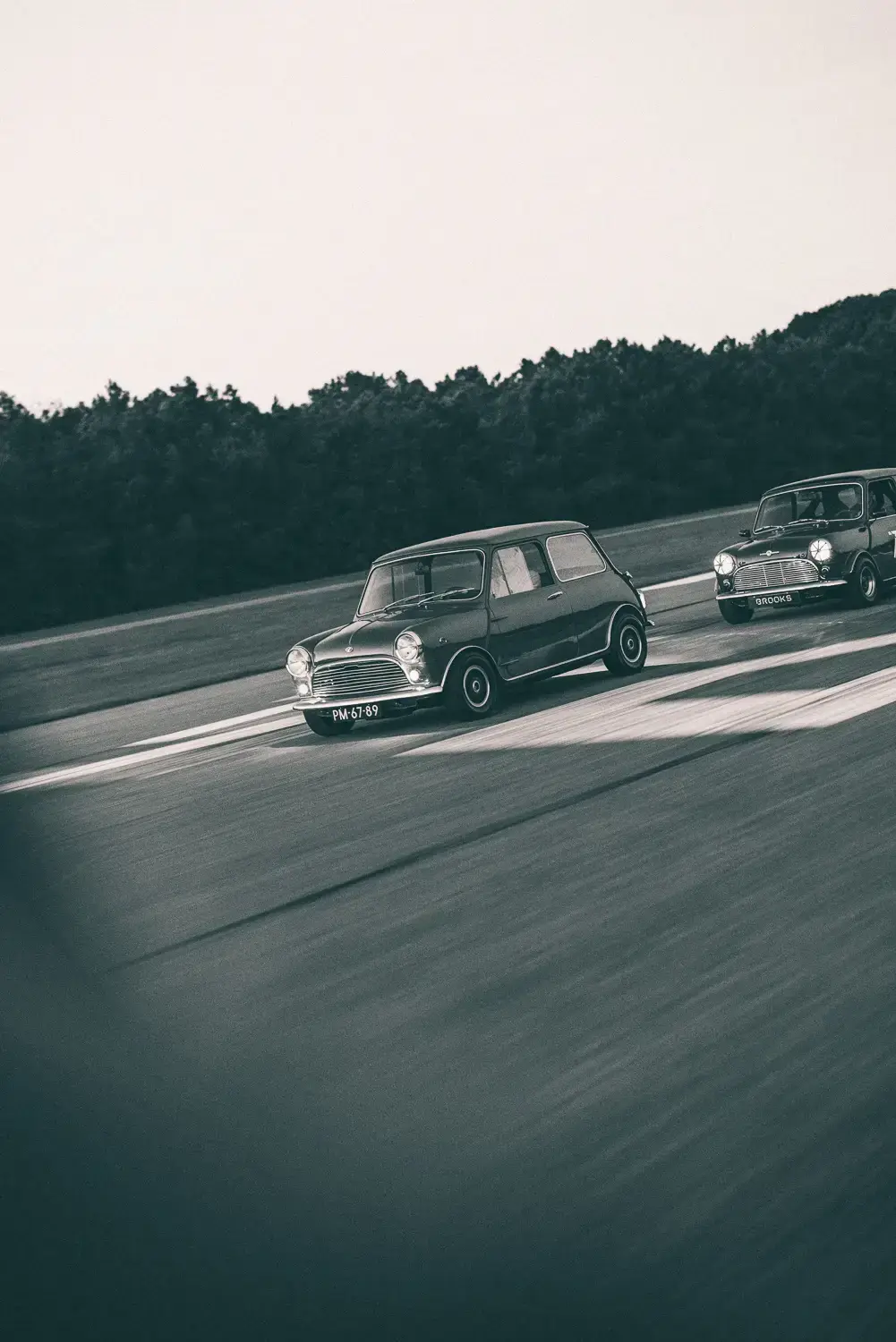 black and white picture of a mini mk1 driving on an airstrip, picture by paul jasper fotografie