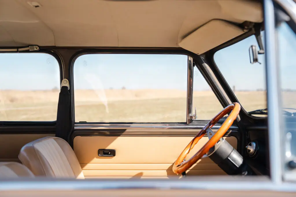 mini classic 1973 interior. light cream seats with wooden dash and wooden MOMO steering wheel