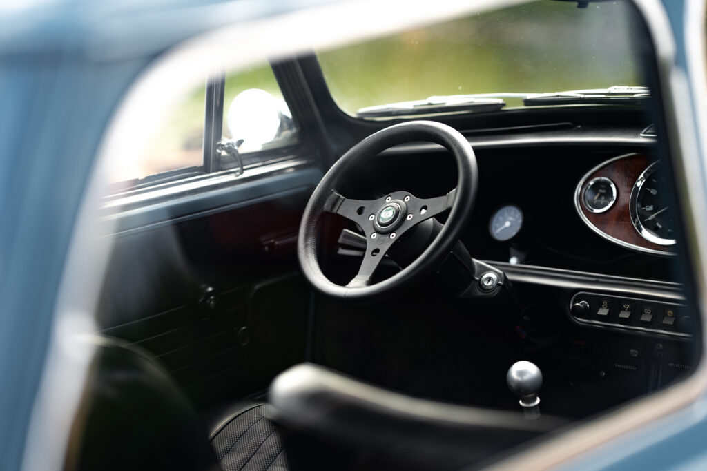 look into the interior of a mini classic, with visible RAID steering wheel and 3 clock dashboard